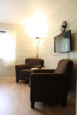 a living room with two chairs and a flat screen tv at Jostedal Hotel in Jostedal