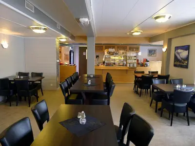 a restaurant with tables and chairs and a counter at Jostedal Hotel in Jostedal
