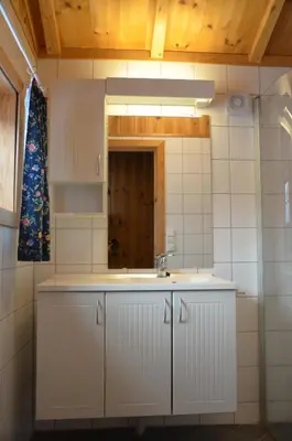 a white kitchen with a sink and a mirror at Northern gate Besseggen - Cottage no 17 in Besseggen Fjellpark Maurvangen in Maurvangen