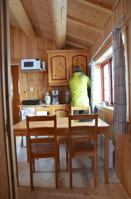 a kitchen with a wooden table and chairs at Northern gate Besseggen - Cottage no 17 in Besseggen Fjellpark Maurvangen in Maurvangen