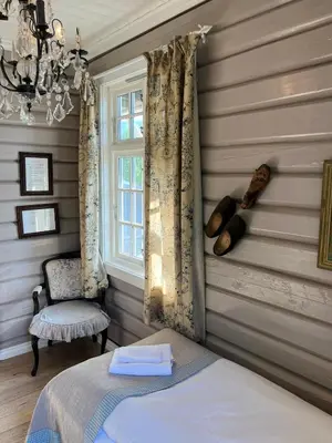 a bedroom with a bed and a chair and a window at Eggedal Borgerstue in Eggedal
