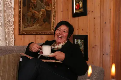 a woman sitting on a couch holding a coffee cup at Eggedal Borgerstue in Eggedal