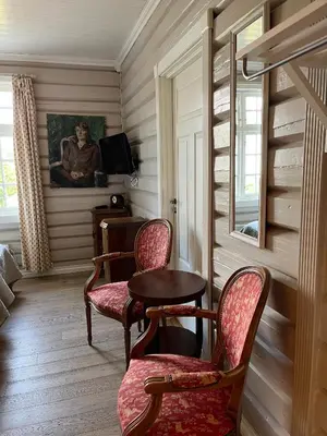 a room with two chairs and a table and a painting at Eggedal Borgerstue in Eggedal