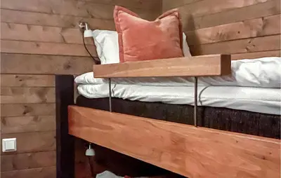 a bed with a wooden headboard with a pillow on it at 5 Bedroom Cozy Home In Hemsedal in Hemsedal