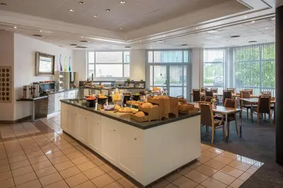 a restaurant with a counter with food on it at Scandic Hønefoss in Hønefoss