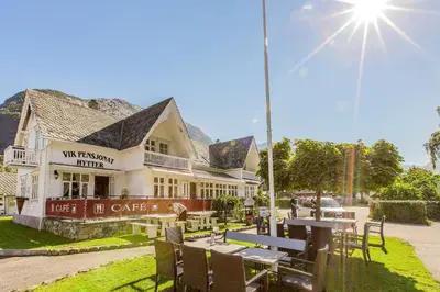 a building with tables and chairs in front of it at Vik Pensjonat in Eidfjord