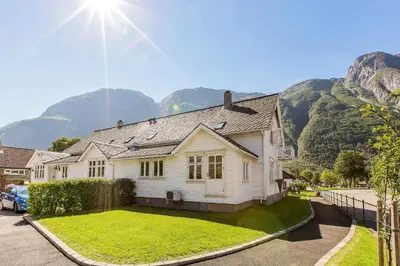 a white house with mountains in the background at Vik Pensjonat in Eidfjord