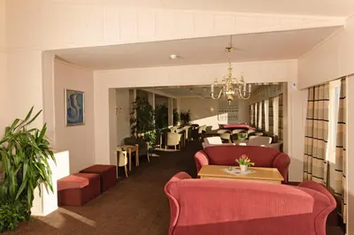 a lobby with red furniture and a dining room at Rødungstøl Høyfjellshotell in Rødungstøl