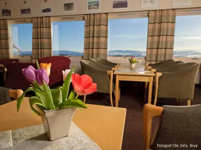 a room with tables and chairs with flowers on them at Rødungstøl Høyfjellshotell in Rødungstøl
