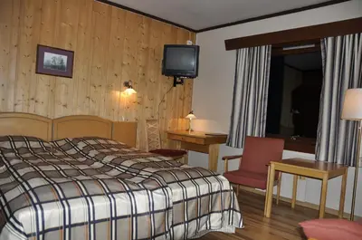 a hotel room with a bed and a television at Rødungstøl Høyfjellshotell in Rødungstøl