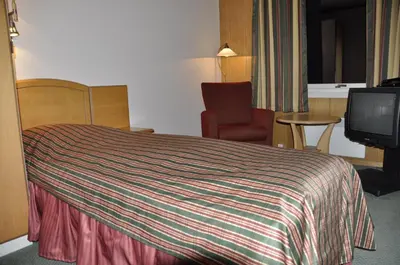 a hotel room with a bed and a tv at Rødungstøl Høyfjellshotell in Rødungstøl