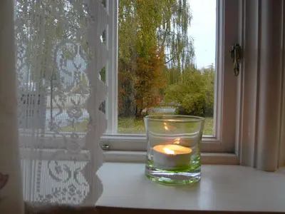a candle in a glass sitting on a window sill at Hagaled Gjestegård in Nesbyen