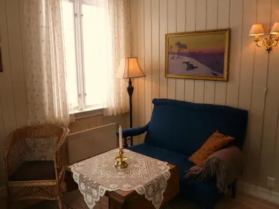 a living room with a blue couch and a table at Hagaled Gjestegård in Nesbyen