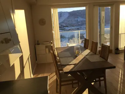 a dining room with a table with a wine glass on it at Geilo Superior leilighet in Geilo