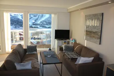 a living room with two couches and a table at Geilo Superior leilighet in Geilo