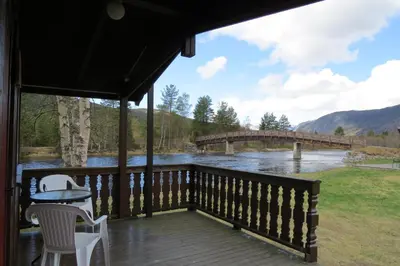 a porch with a view of a bridge over a river at Camp Uvdal in Uvdal