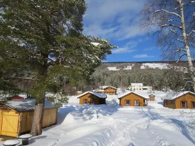 a village covered in snow with wooden cabanas at Camp Uvdal in Uvdal