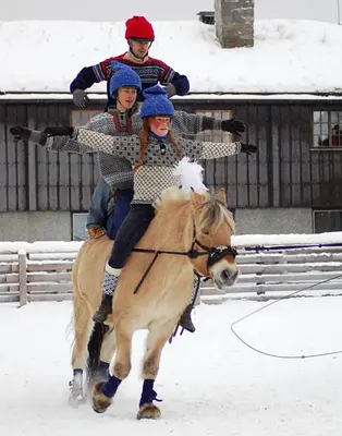 three people riding on a horse in the snow at Langedrag Naturpark in Tunhovd