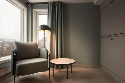 a room with a chair and a table and a window at Scandic Victoria Lillehammer in Lillehammer