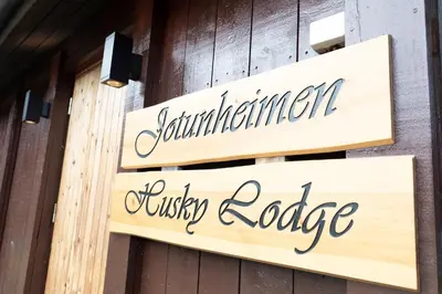 a couple of signs on the side of a building at Jotunheimen Husky Lodge in Randsverk