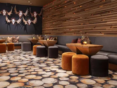 a restaurant with a row of tables and stools at Radisson Blu Resort, Trysil in Trysil