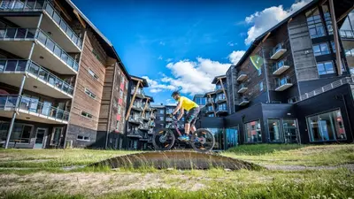a man riding a bike on a fountain in front of buildings at Radisson Blu Resort, Trysil in Trysil
