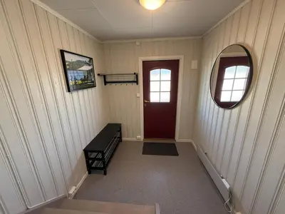 a hallway with a red door and a mirror at Sveastranda Camping in Gullor