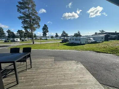 a picnic table and chairs on a patio with a camping site at Sveastranda Camping in Gullor
