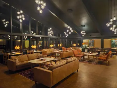 a restaurant with couches and tables and chandeliers at Honne Hotell in Biri