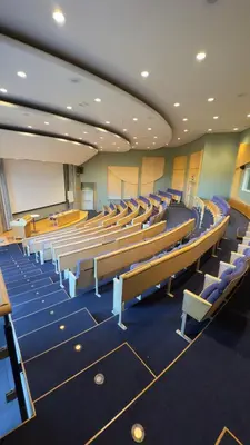 a lecture hall with rows of chairs and a whiteboard at Honne Hotell in Biri