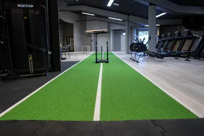 a gym with a green floor and tread machines at Honne Hotell in Biri