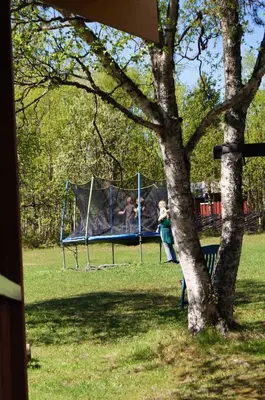 two children playing on a trampoline in a park at Bustad Hyttetun in Skåbu