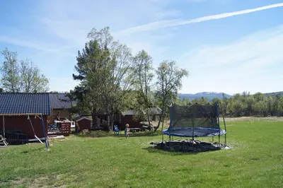 a blue trampoline in the grass in a yard at Bustad Hyttetun in Skåbu