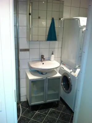 a bathroom with a sink and a washing machine at Central location in the heart of historic Bergen in Bergen