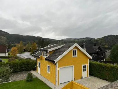 a yellow house with solar panels on top of it at Sandvik Garasjeloft in Vossevangen