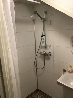 a shower with a shower head in a bathroom at Sandvik Garasjeloft in Vossevangen