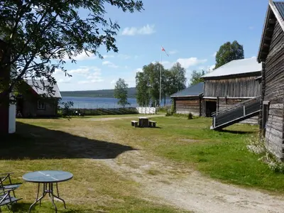 a picnic table next to a barn and a lake at Vestre Sorken Feriegard in Drevsjø