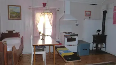 a kitchen with a table and a stove and a window at Vestre Sorken Feriegard in Drevsjø