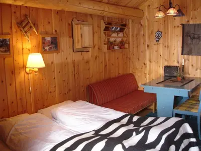 a bedroom with a bed and a desk and a table at Vestre Sorken Feriegard in Drevsjø