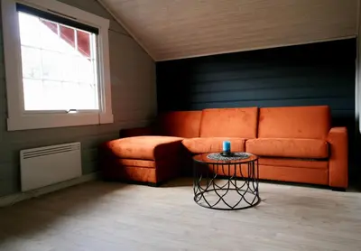 a living room with an orange couch and a table at Bøflaten Camping AS in Vang I Valdres