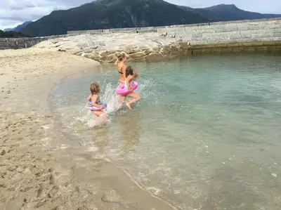 three girls are playing in the water on the beach at Villa Holmen 2 - Ground floor apartment in Balestrand
