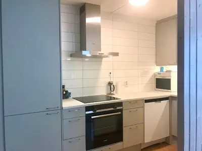 a white kitchen with a sink and a stove at Villa Holmen 2 - Ground floor apartment in Balestrand