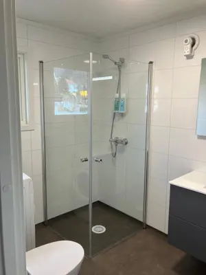 a shower with a glass door in a bathroom at Villa Holmen 2 - Ground floor apartment in Balestrand