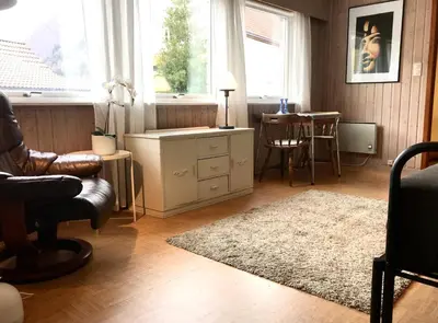 a living room with a chair and a table at Villa Holmen 2 - Ground floor apartment in Balestrand