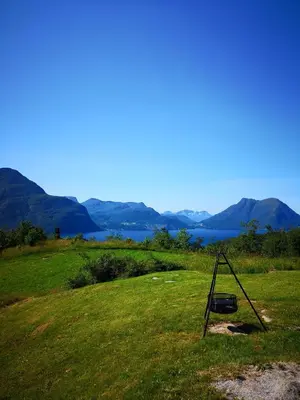 a swing in a field with mountains in the background at Fjords view in Sjøholt
