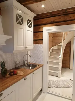 a kitchen with white cabinets and a staircase in the background at Fjords view in Sjøholt