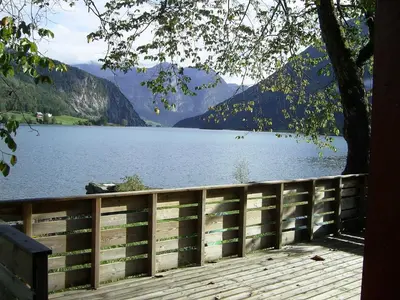 a view of a lake behind a wooden fence at Mindresunde Camping in Mindresunde