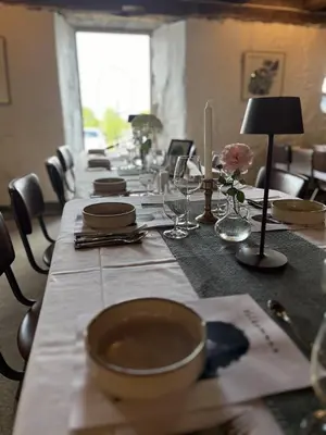 a long table with plates and bowls on top of it at Klostergården Bed & Breakfast in Tautra