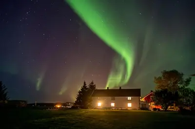 a house with the aurora in the sky at Klostergården Bed & Breakfast in Tautra