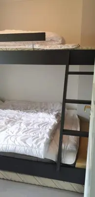 a set of bunk beds with a white bed at Oppdal Alpintun Stølen ski in - ski out in Oppdal